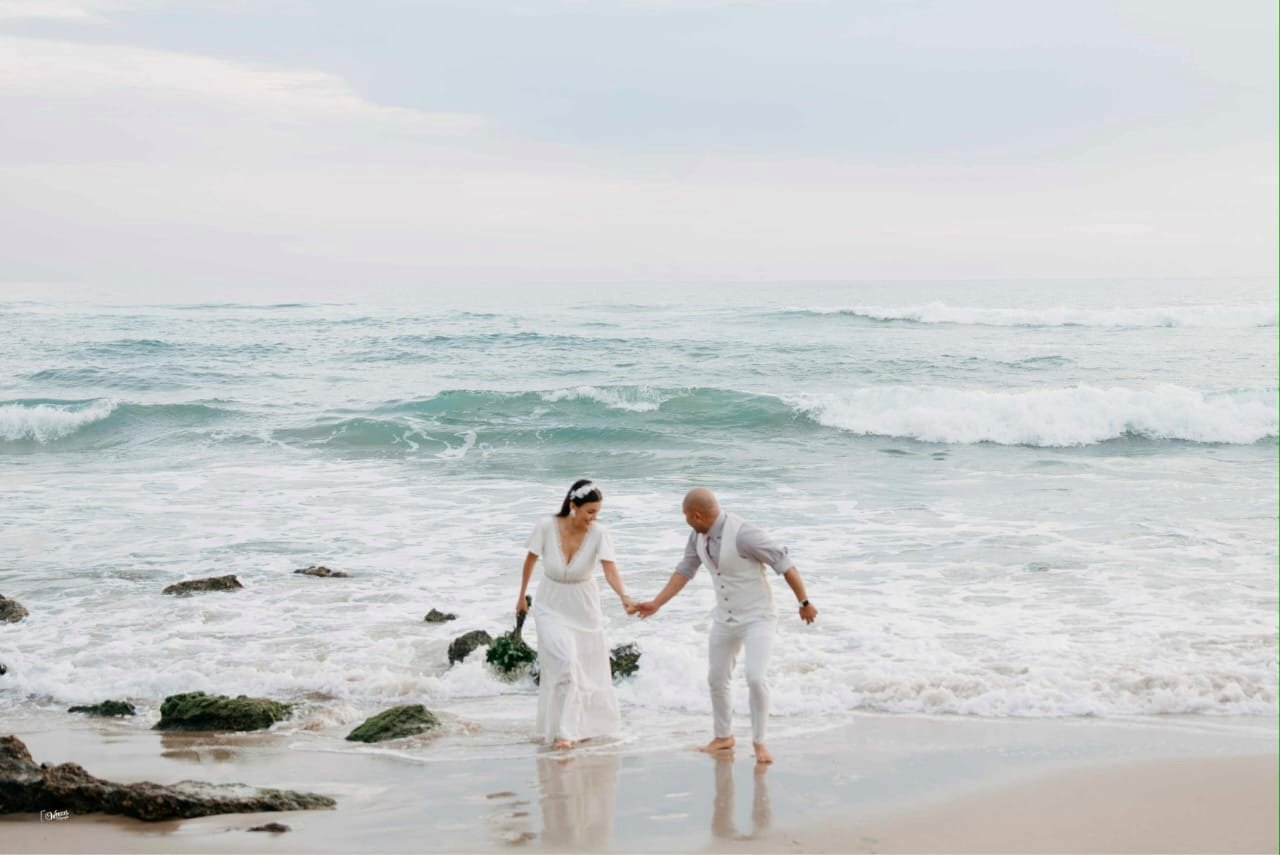 Imene y Walter caminando de la mano en la playa