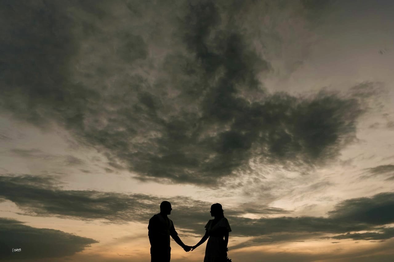 Silueta de Imene y Walter tomados de la mano al atardecer
